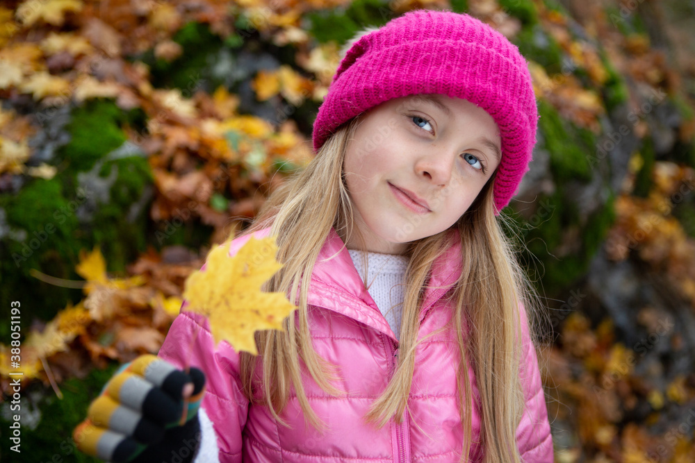 8 year old girl with colorful clothes holding leaf outdoors in the forest on an october autumn day 8 year old girl with colorful clothes holding leaf outdoors in the forest on an october autumn day