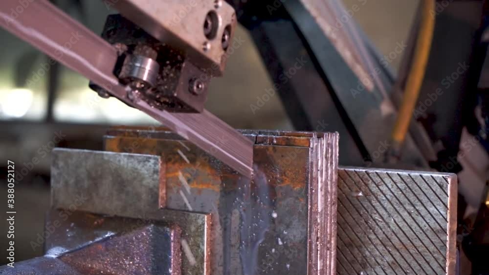 SAWING MACHINE, The band saw for industrial cutting the metal rod and using the coolant in light blue scene.The industrial tool. SAWING MACHINE, The band saw for industrial cutting the metal rod and using the coolant in light blue scene.The industrial tool.