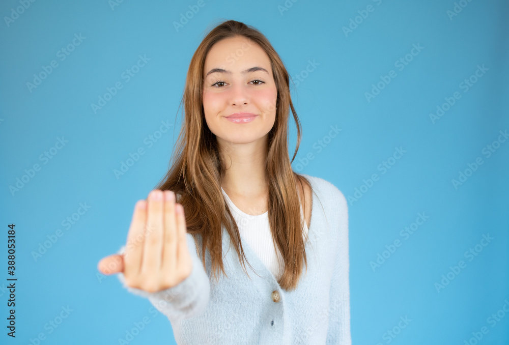 Young pretty woman inviting to come, confident and smiling making a gesture with hand, being positive and friendly Young pretty woman inviting to come, confident and smiling making a gesture with hand, being positive and friendly