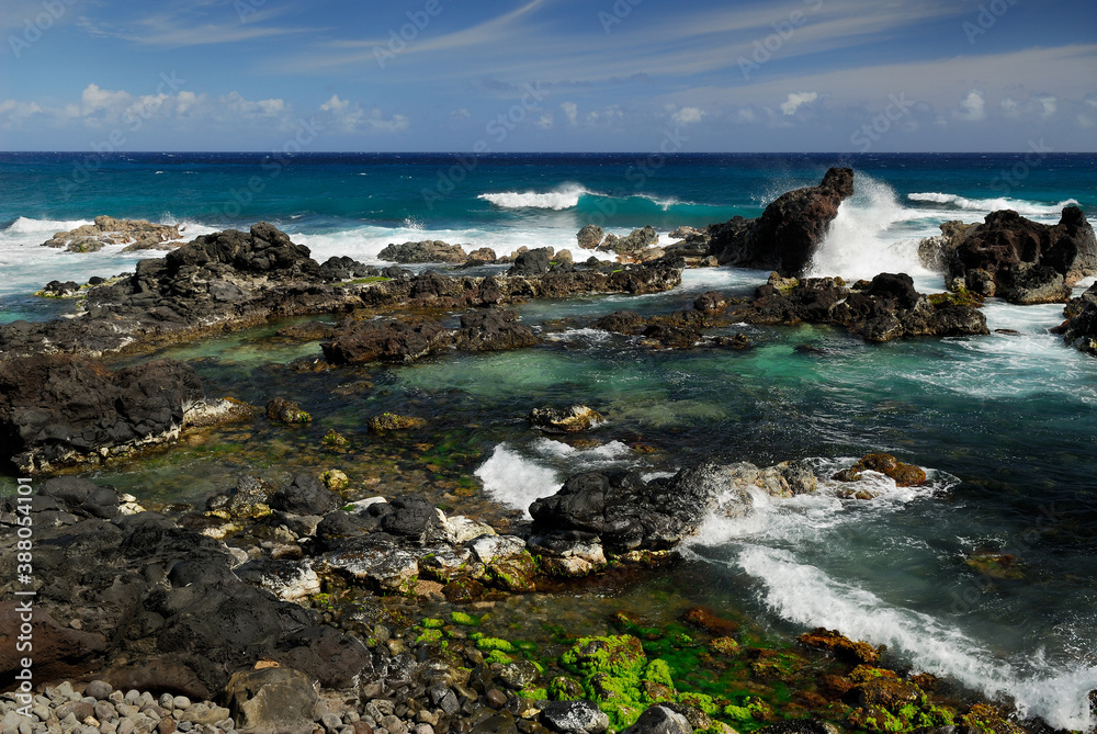 Blue wave and lava rock tide pools at Hookipa Beach Maui