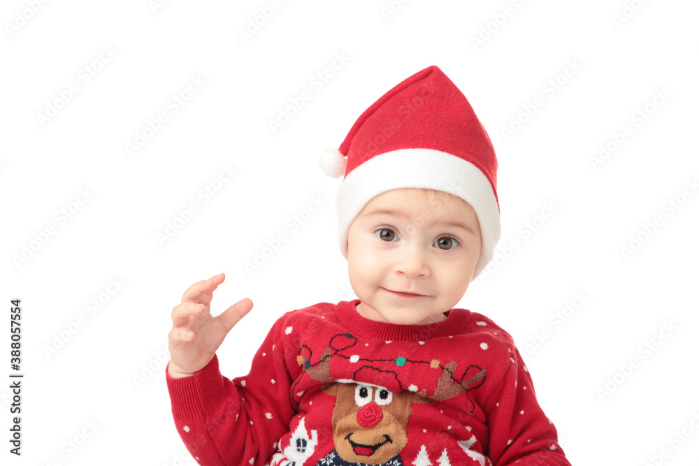 Adorable child is sitting on floor, wearing red Christmas hat, isolated over white Adorable child is sitting on floor, wearing red Christmas hat, isolated over white
