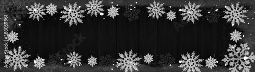 Christmas snow winter background banner panorama - Frame made of snow with snowflakes and ice crystals on dark black wooden wood texture, top view with space for text