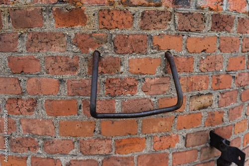 large metal staples in a brick wall. ladder on a large pipe