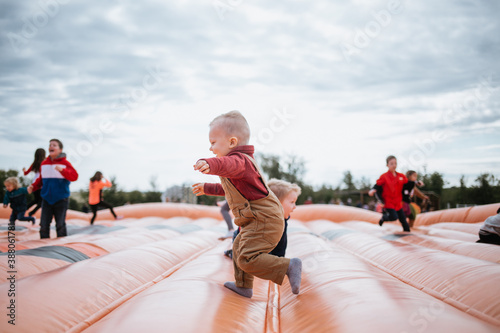 Murais de parede Happy toddler playing on outdoor bounce house in the fall