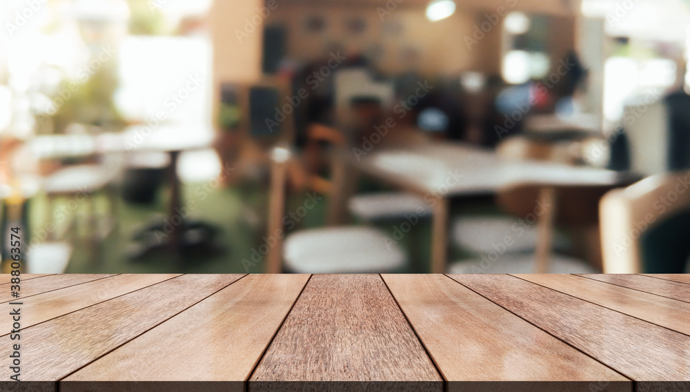 Empty wooden table top with lights bokeh on blur restaurant background.