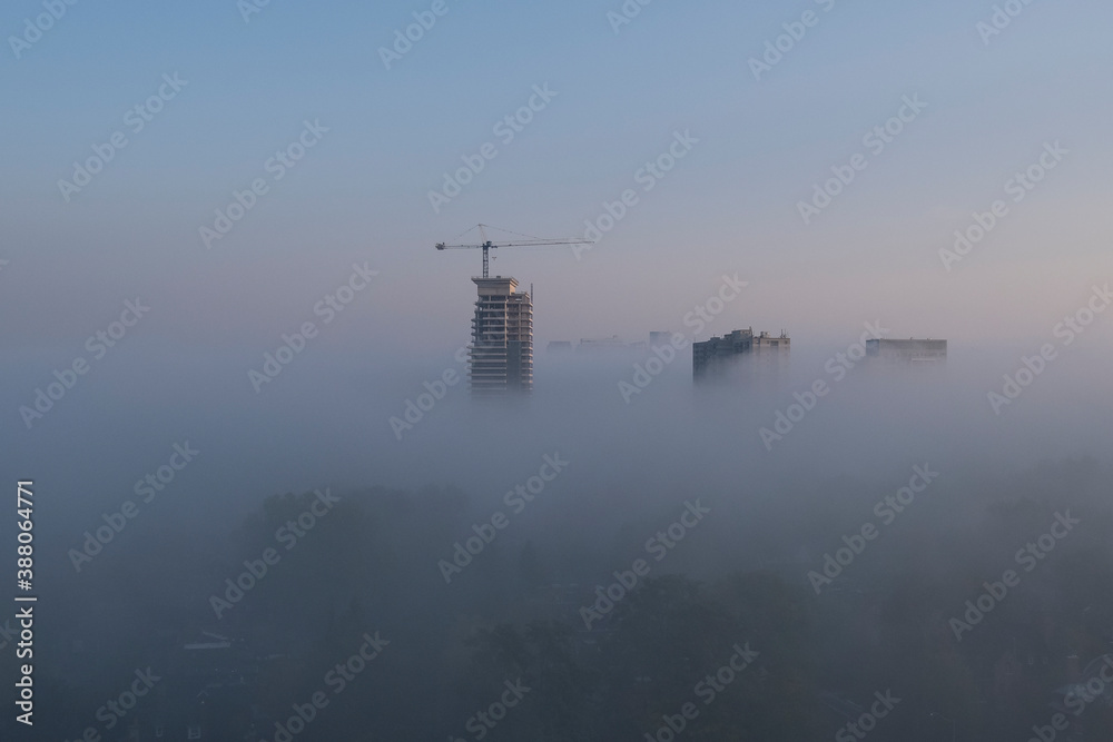 Construction crane in urban fog