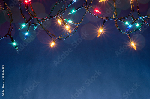 Christmas lights on blue background with copy space.