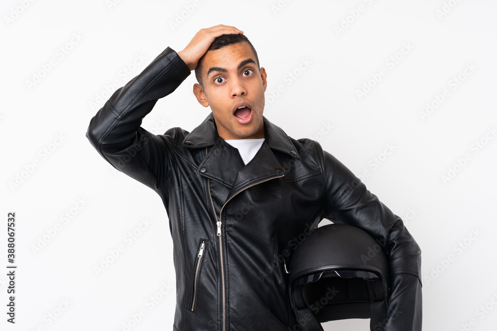 Young handsome man with a motorcycle helmet over isolated white background with surprise facial expression Young handsome man with a motorcycle helmet over isolated white background with surprise facial expression