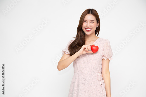 Attractive young Asian woman holding red love heart isolated on white background