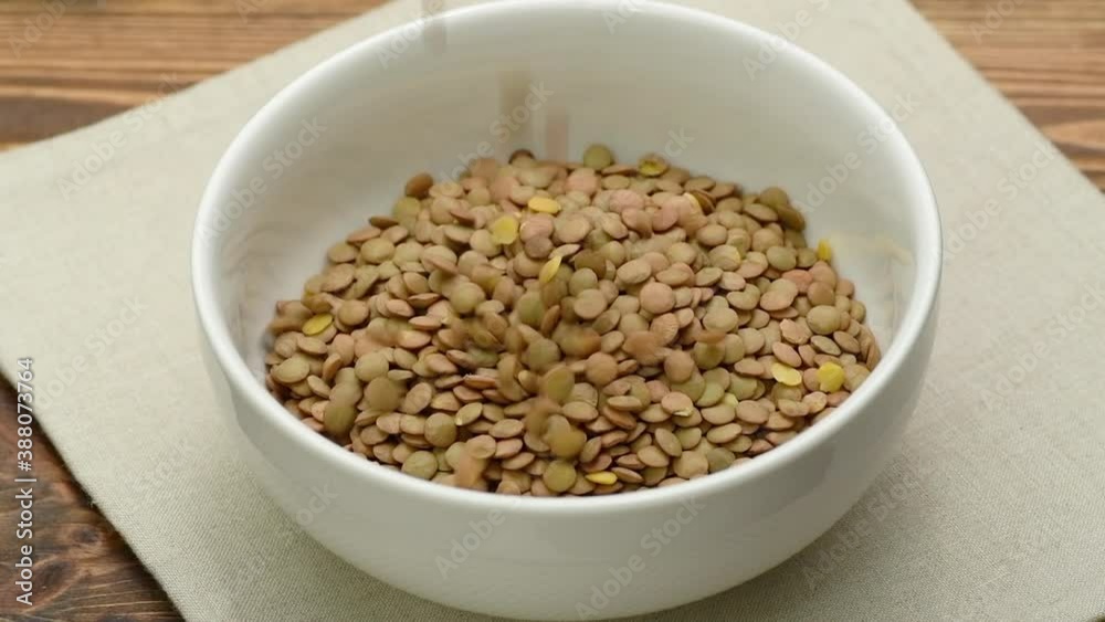 Dry raw green lentils falling into a white bowl, slow motion, close up
Dry raw green lentils falling into a white bowl, slow motion, close up