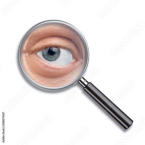 enlarged focused man's eye in magnifier glass photo