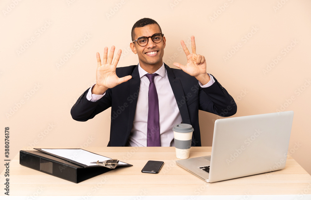 Young business man in his office with a laptop and other documents counting eight with fingers Young business man in his office with a laptop and other documents counting eight with fingers