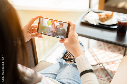 young woman is watching a happy video with her boyfriend recorded last year's Christmas day and she misses her boyfriend for being separated from the covid-19 or coronavirus outbreak