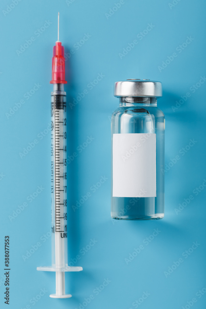 Ampoule with a vaccine and a syringe for viruses and diseases on a blue background. Ampoule with a vaccine and a syringe for viruses and diseases on a blue background.