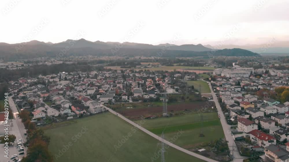 Power Lines On The Meadow Surrounded By Houses In A Village In Slovenia - aerial tilt-up shot Power Lines On The Meadow Surrounded By Houses In A Village In Slovenia - aerial tilt-up shot