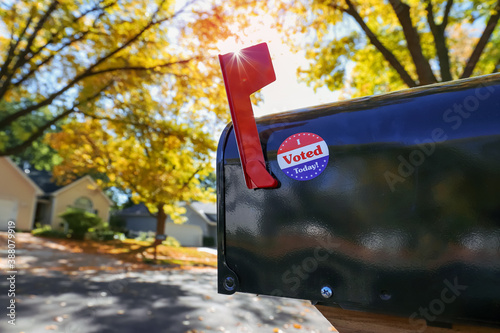 Obraz na płótnie Mailbox with an I voted today sticker on it with sun flare behind flag, absent