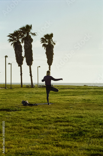 Man doing yoga in a park by the sea photo