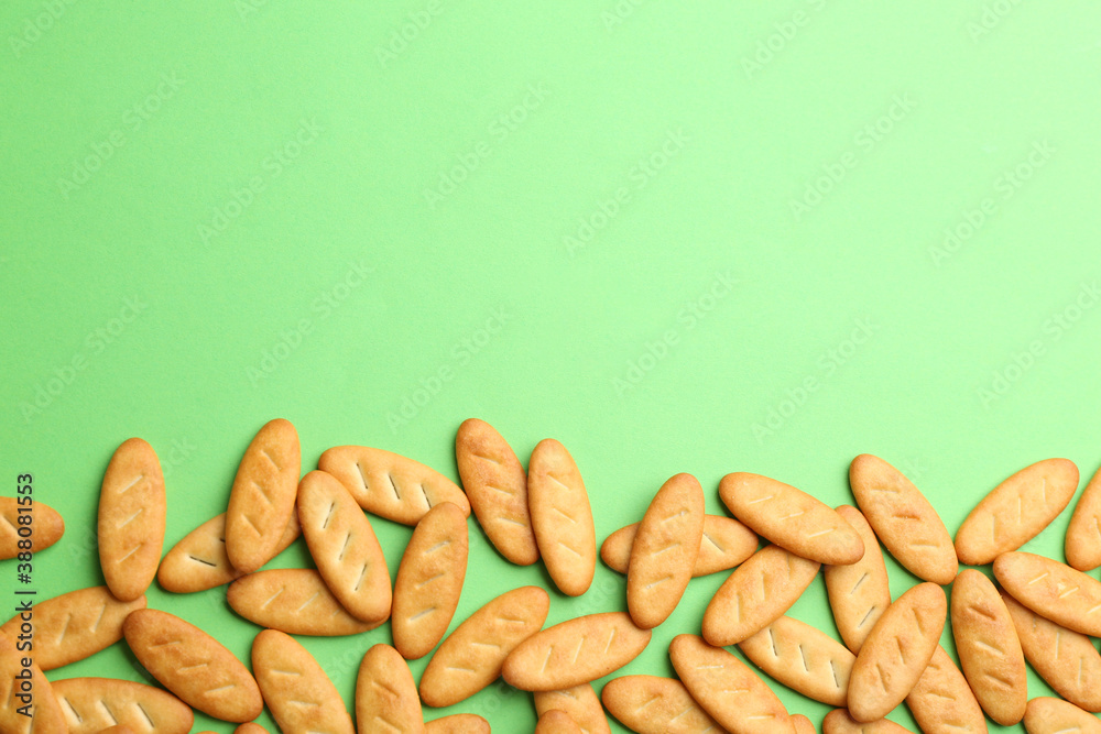 Obraz premium Delicious crackers on light green background, flat lay. Space for text