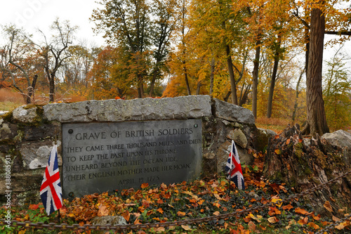 Gravestone of British Soldiers killed at North Bridge at Minute Man National Historical Park, Concord MA.  Picture shows grave and North Bridge. photo