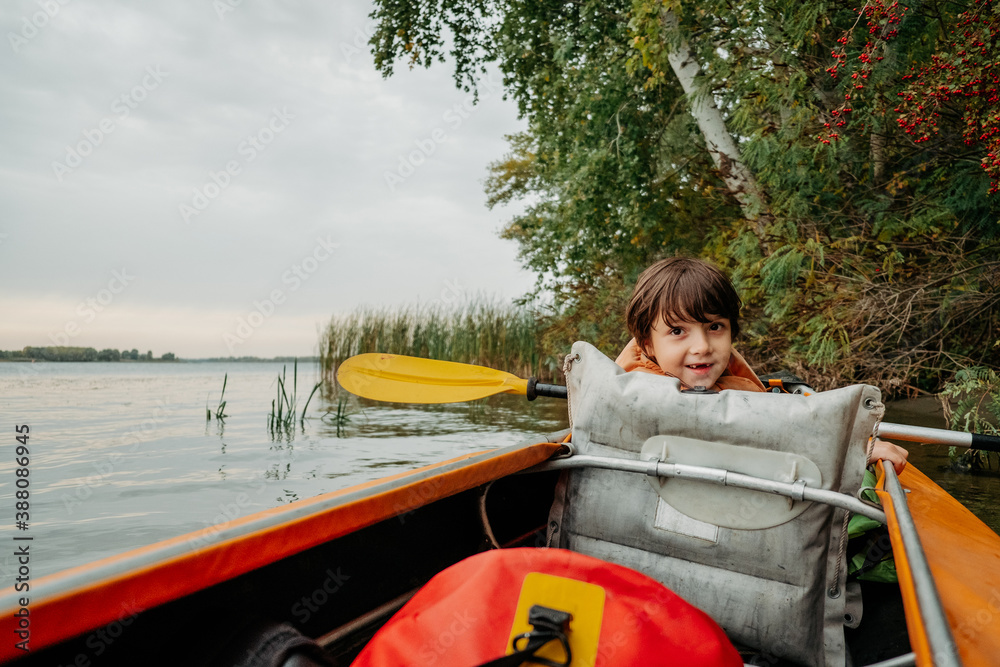 Evening kayak trip along the river in autumn. The active lifestyle of the child in the family. Evening kayak trip along the river in autumn. The active lifestyle of the child in the family.