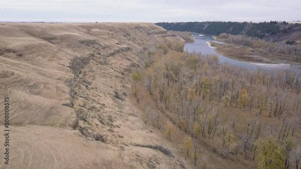 Dry autumn aerial down lower Bow River Valley with eroded hillside Dry autumn aerial down lower Bow River Valley with eroded hillside