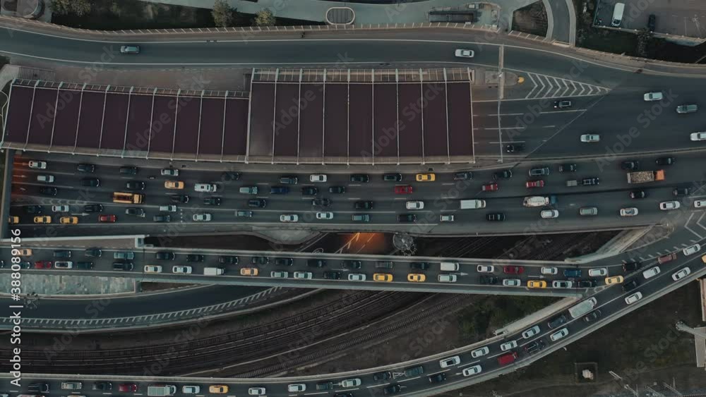 Multiple lane road with cars in peak hours, aerial view of cars moving on the road. Drone shot flying up many cars on a highway road, cloudy weather Multiple lane road with cars in peak hours, aerial view of cars moving on the road. Drone shot flying up many cars on a highway road, cloudy weather