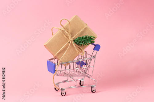 Gift box wrapped in kraft paper in a shopping basket. Gift shopping concept, online store