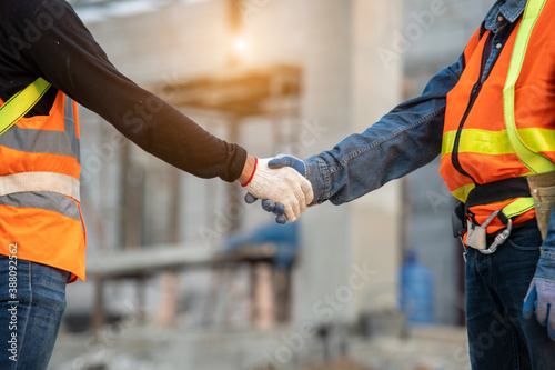 Foto Close up two engineers builders hands in gloves greeting each other with handshake at construction site