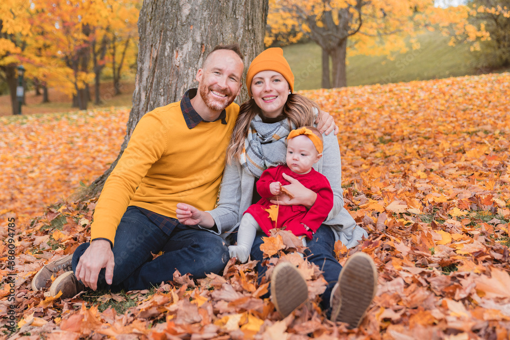 Baby daughter and her parents in the autumn season in park Baby daughter and her parents in the autumn season in park