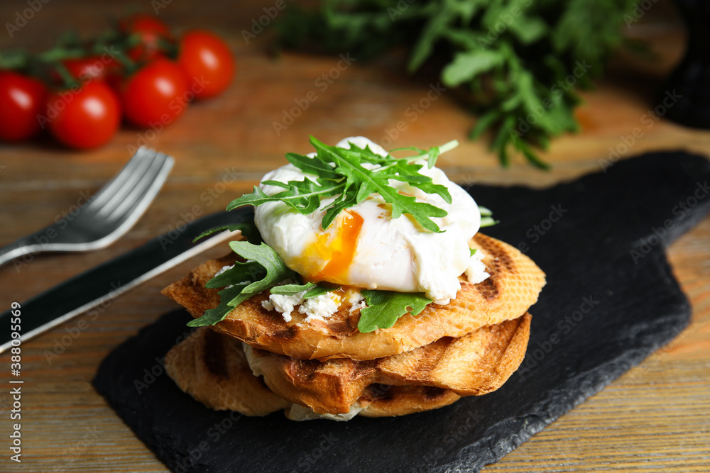 Delicious sandwich with arugula and egg on wooden table, closeup