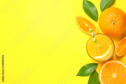 Glass of orange juice and fresh fruits on yellow background, flat lay. Space for text