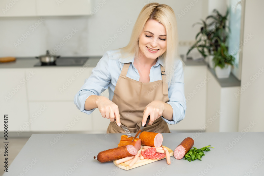 The girl is eating sausage. A piece of sausage. Smile and Joy. Business concept is the brand's appeal. Appetite The girl is eating sausage. A piece of sausage. Smile and Joy. Business concept is the brand's appeal. Appetite