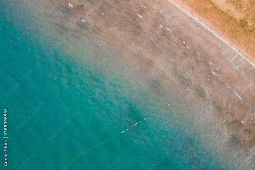 Blue sea and yellow sand top down aerial view