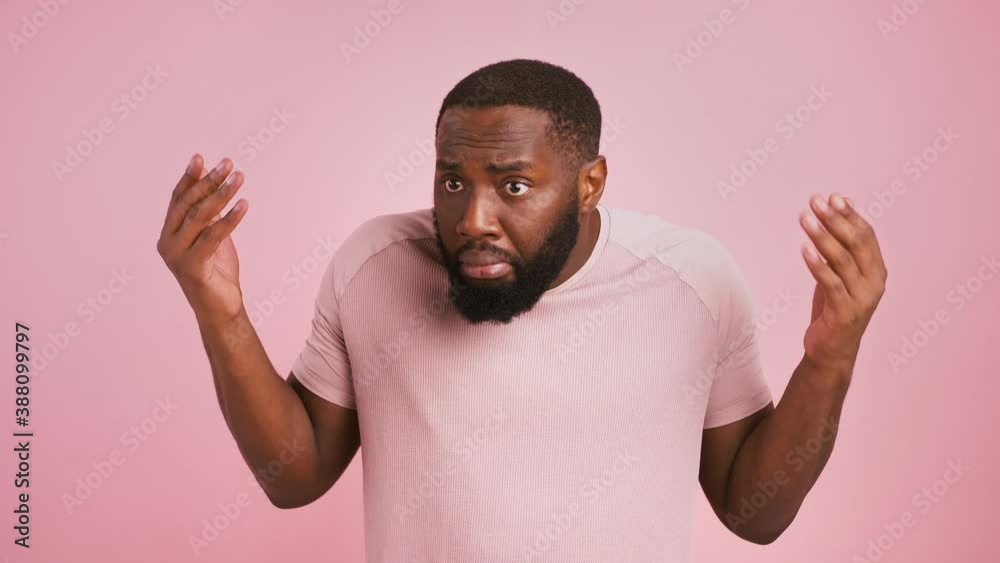African american man raising his hands, waiting for excusement, pink studio background African american man raising his hands, waiting for excusement, pink studio background