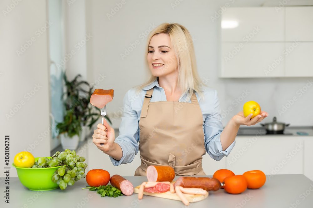 woman holds and chooses between meat and apple woman holds and chooses between meat and apple