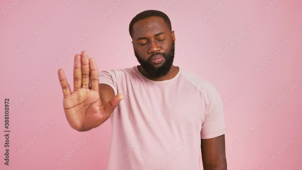 Serious black guy gesturing stop, looking at camera and shaking head no, pink studio background Serious black guy gesturing stop, looking at camera and shaking head no, pink studio background