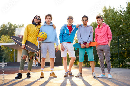 portrait of positive group of young people came to play basketball, in casual wear. caucasian boys enjoy time together outdoors