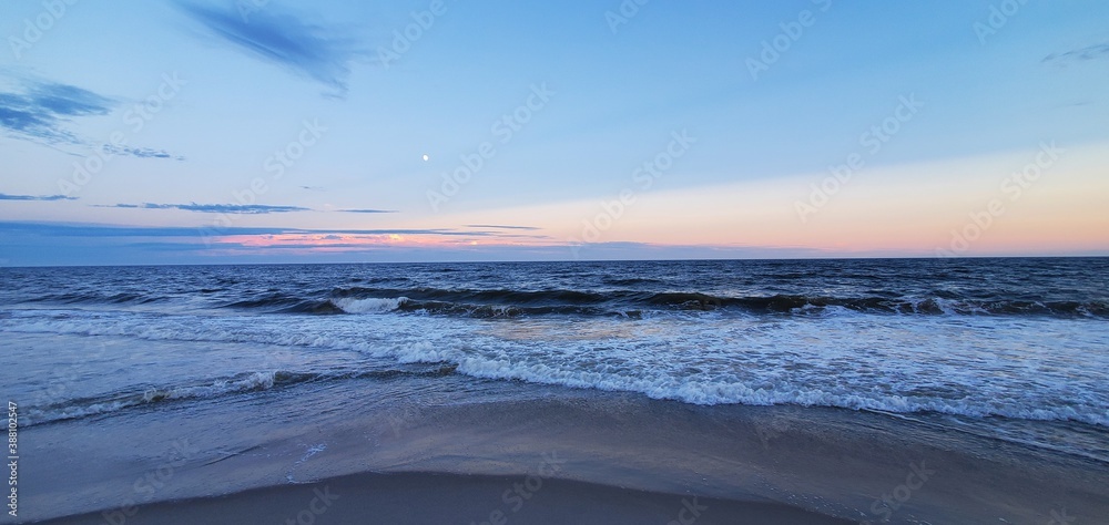 Obraz premium City Beach, Rockaway beach, quiet and empty ocean with a peaceful glow in the background. New York