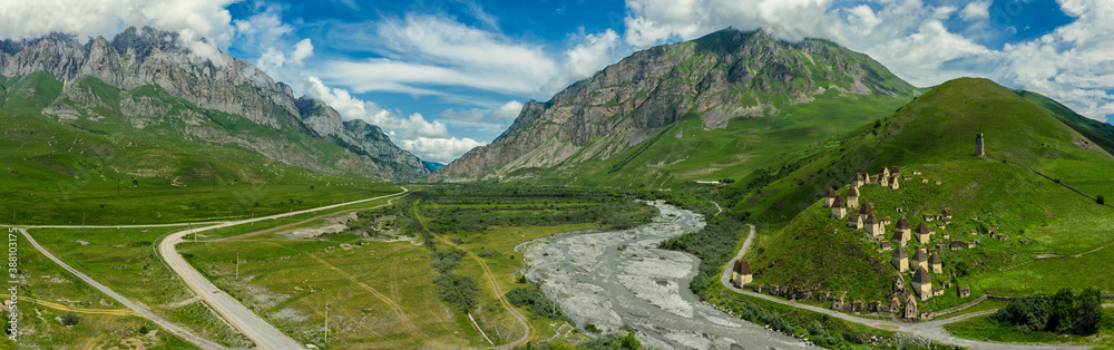 Aerial panorama of Dead Town Dargavs In North Ossetia. The ancient cemetery of the Alans. Many small stone mausoleums, standing on the side of a mountain. Aerial panorama of Dead Town Dargavs In North Ossetia. The ancient cemetery of the Alans. Many small stone mausoleums, standing on the side of a mountain.