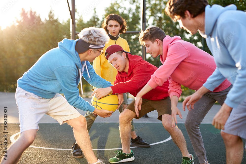 Obraz premium catch it. positive delighted teenager boys play basketball, want to win, every competitor wants to get the ball and score a goal