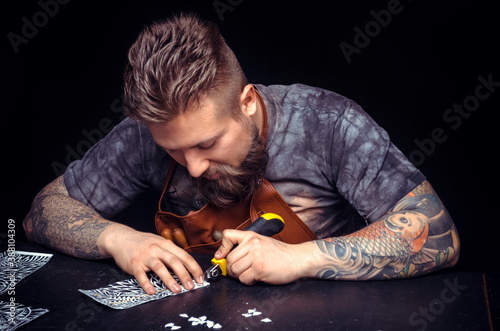 Handyman performing leatherwork on a new product piece in workplace photo