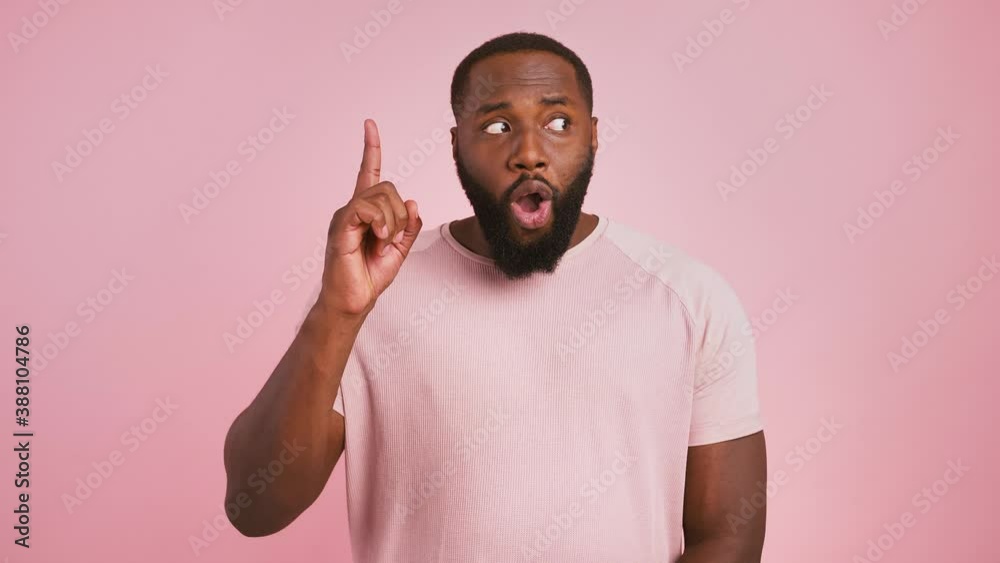 Creative thinking and inspiration. Emotional black guy having idea, pointing finger up, pink background