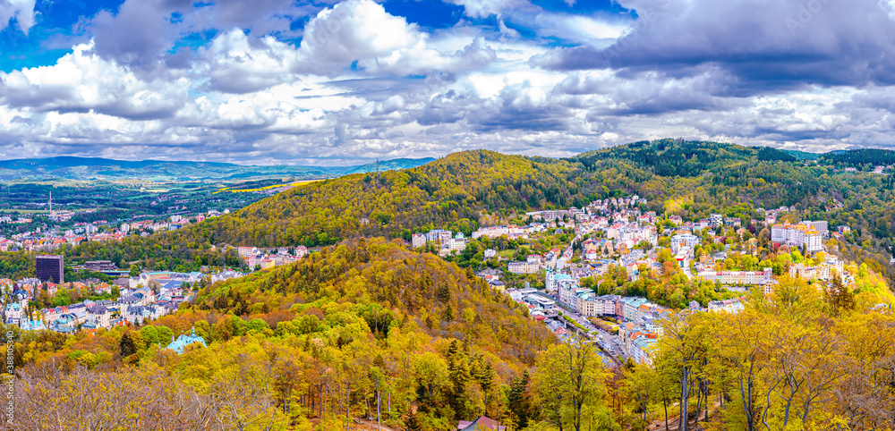 Karlovy Vary city aerial panoramic view with row of colorful multicolored buildings and spa hotels in historical city centre. Panorama of Karlsbad town and Slavkov Forest hills in autumn