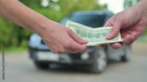 Car sale. A woman gives a man a key and takes money in return, selling him her car