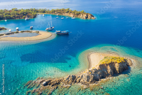 sand island between rock cape and another island and sailing yachts in lagoon with copy space