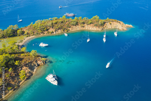 aerial view to rock cliff and lagoon with boats behind it