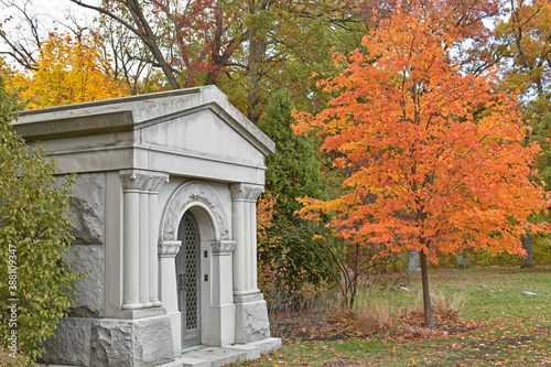 Photo The height of autumn surrounds a private mausoleum in a cemetery