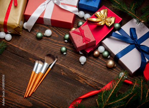 Makeup brushes near Christmas gifts on a table