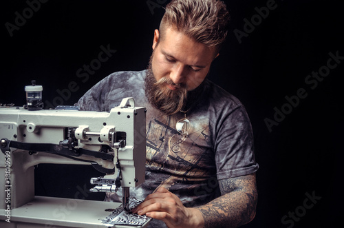 Craftsman working with leather forms new leather product in workshop photo