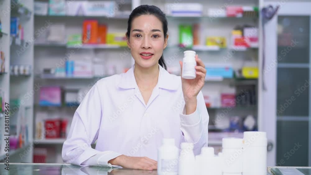 Pharmacist woman describe medicine drug bottle talk a camera at drug store 4k resolution